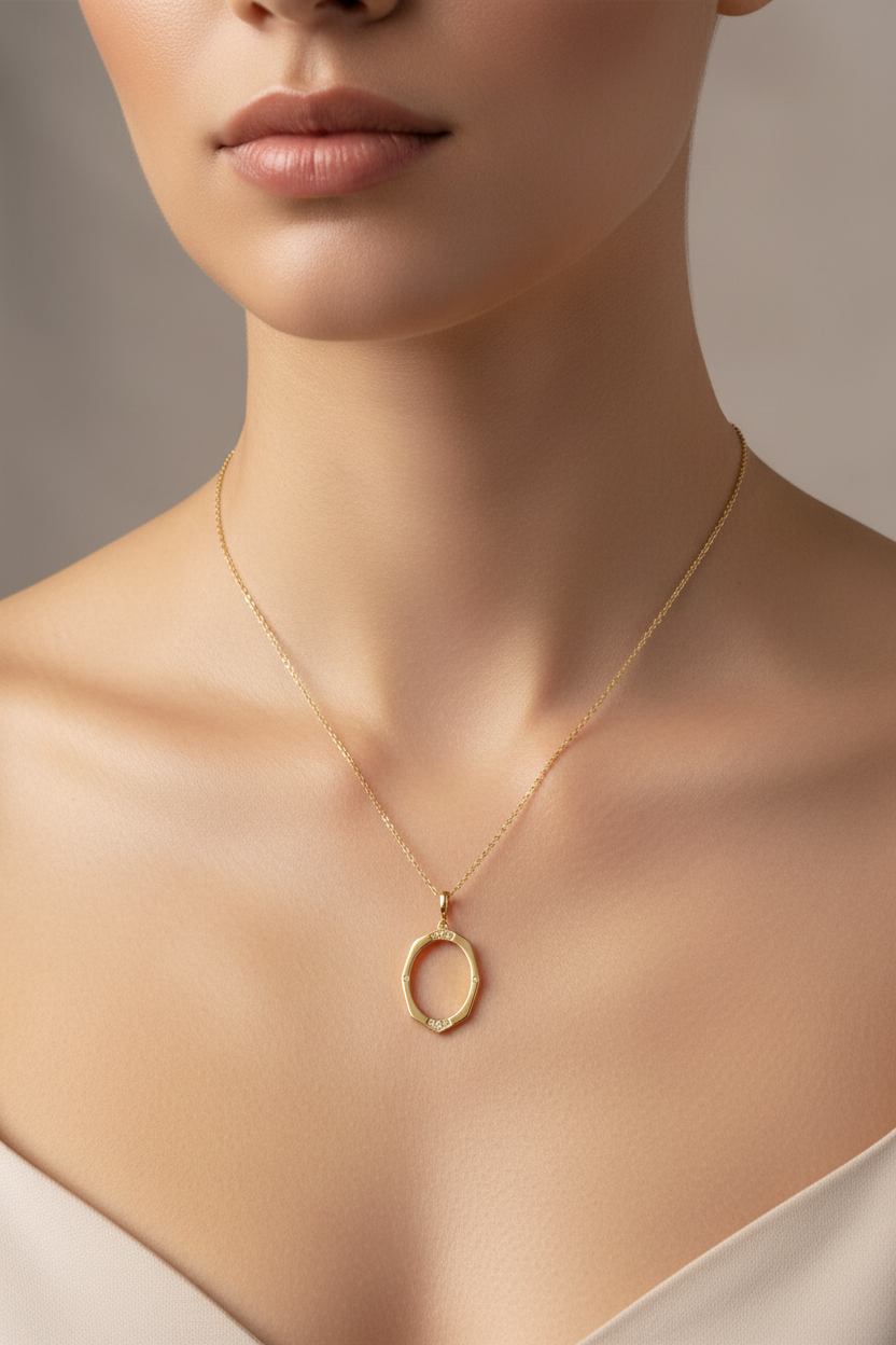 Close-up of gold oval pendant on model