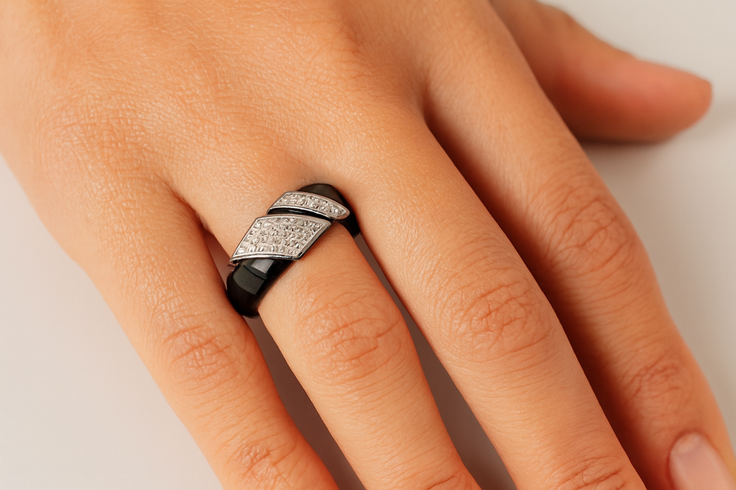 Hand wearing silver ring with crystal details