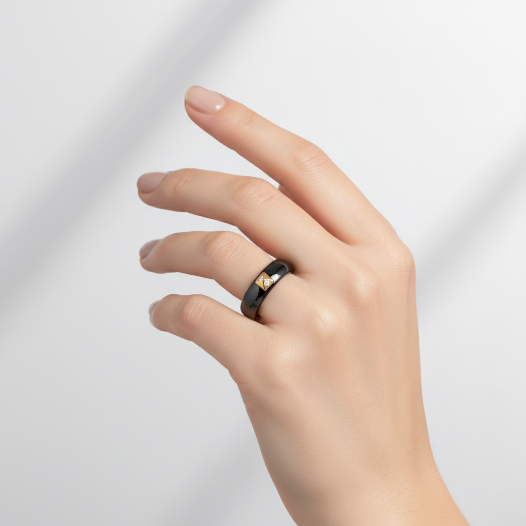 Black ceramic ring with gold triangle on finger