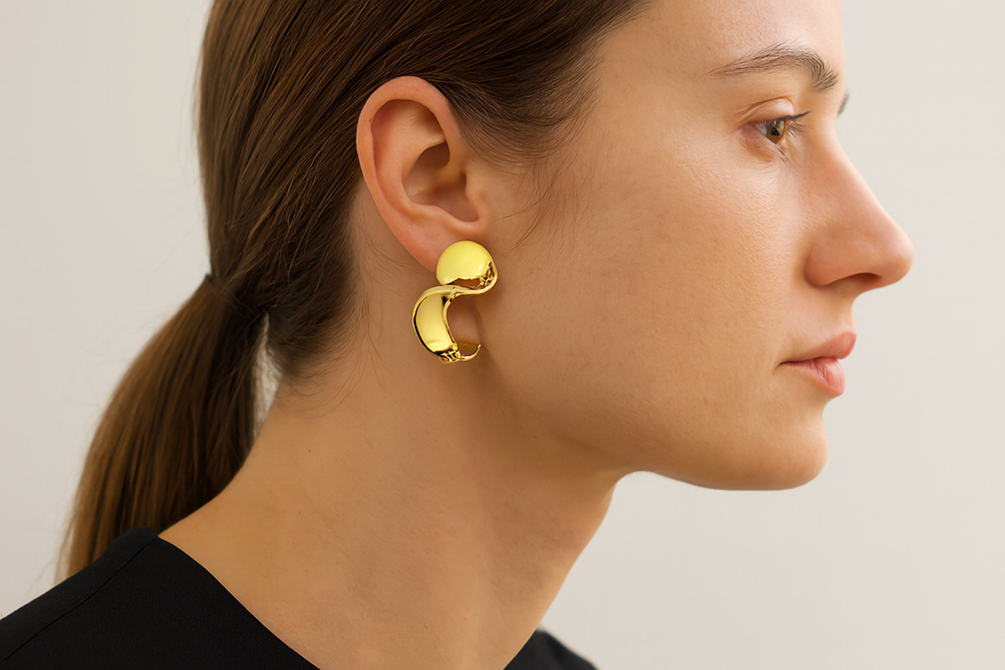 Generated lifestyle image of the sculptural gold earrings being worn