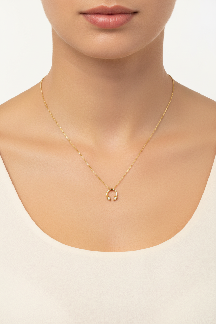Gold horseshoe necklace worn on neck