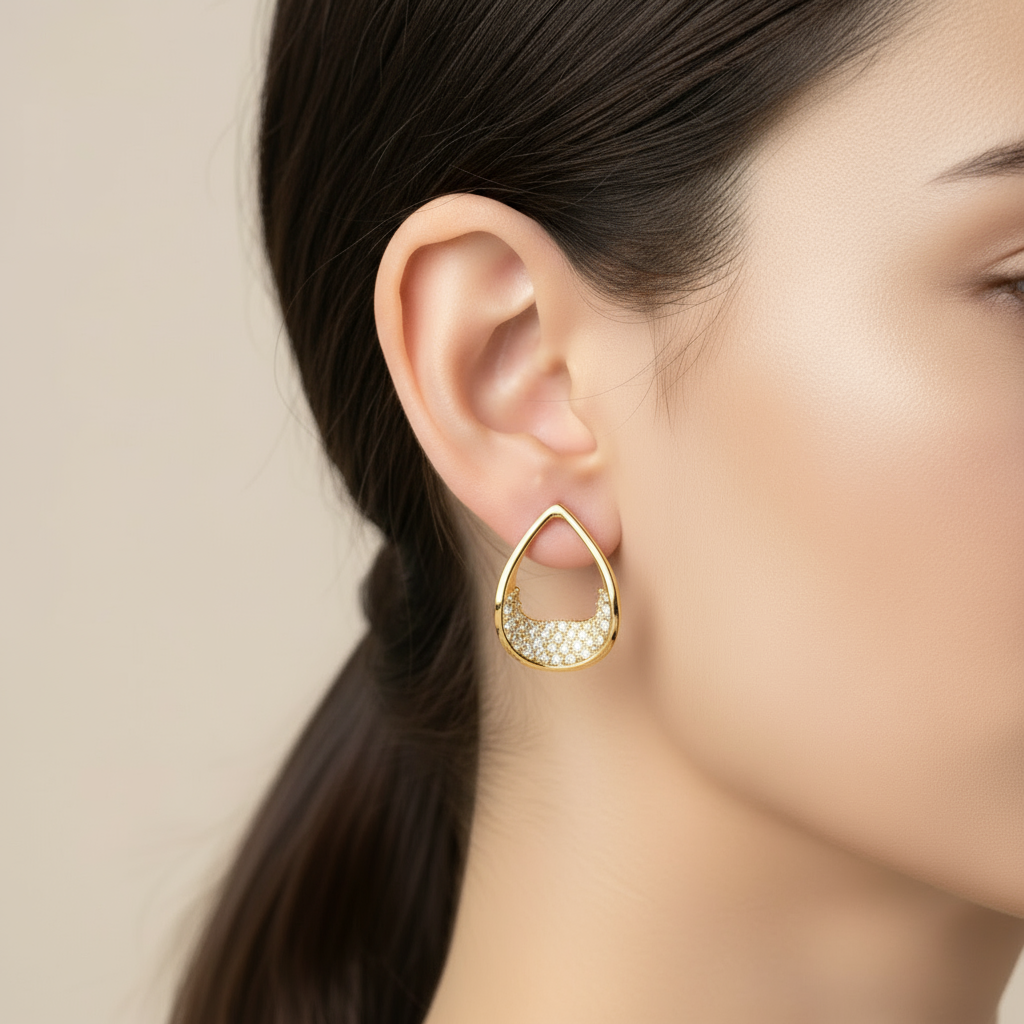 Gold teardrop earrings on model ear