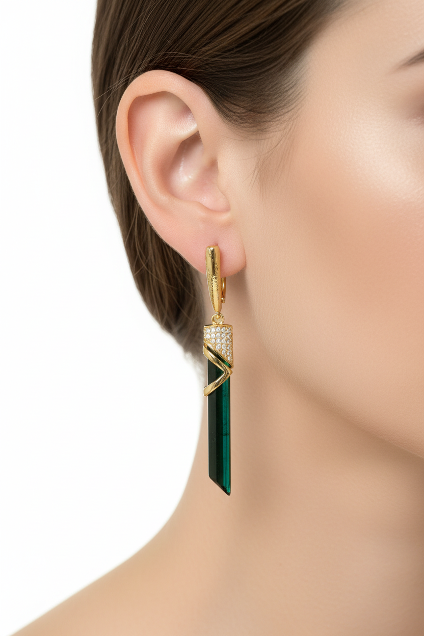 Green tourmaline drop earrings with gold accents worn on ear