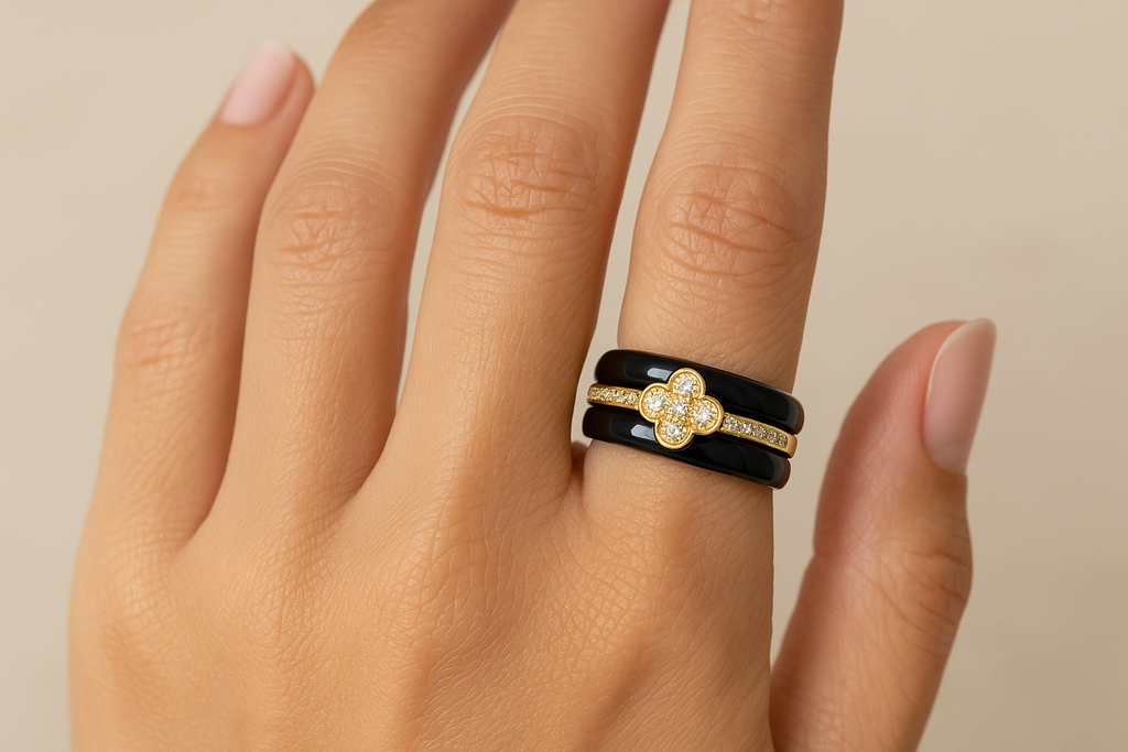 Model wearing black ceramic ring with gold crystal clover design