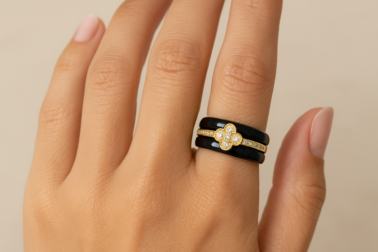 Model wearing black ceramic ring with gold crystal clover design