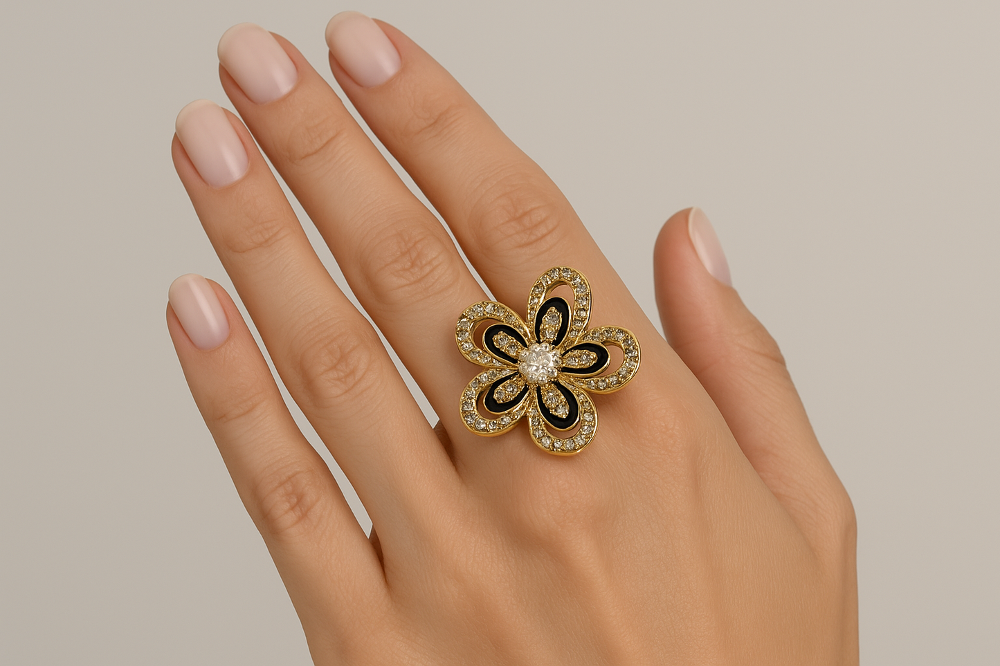 Model wearing ornate gold flower ring with black enamel and crystals