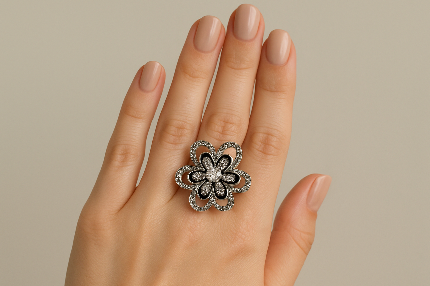 Model wearing ornate silver flower ring with black enamel and crystals