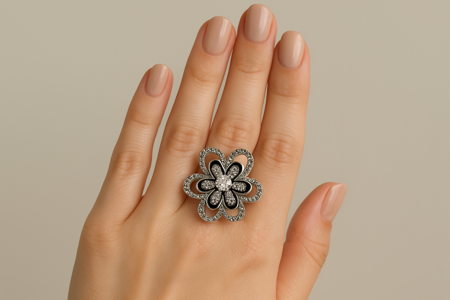 Model wearing ornate silver flower ring with black enamel and crystals