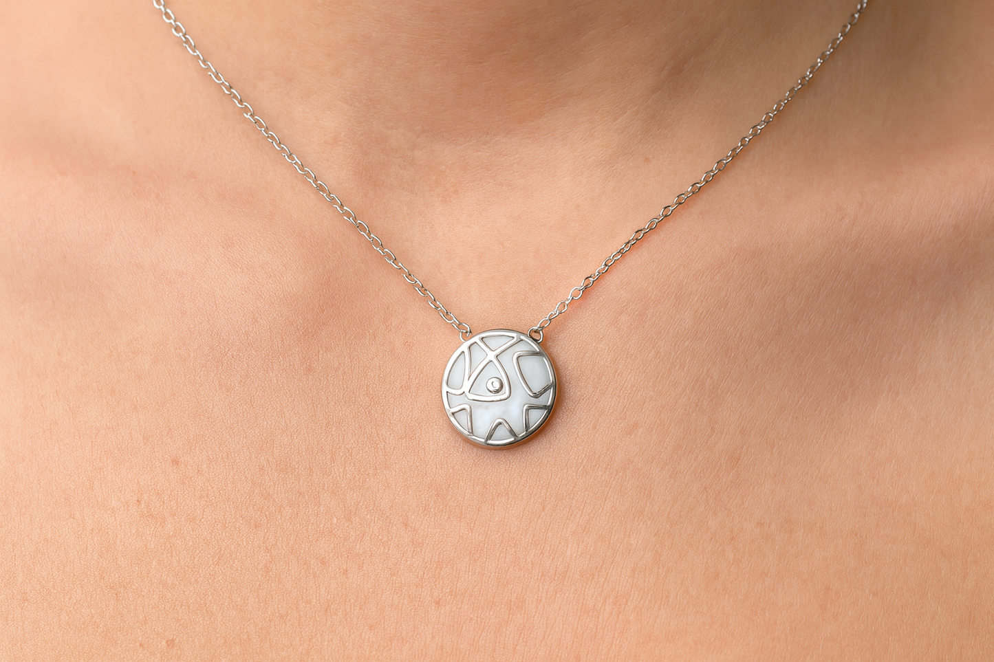 Silver circular pendant necklace being worn