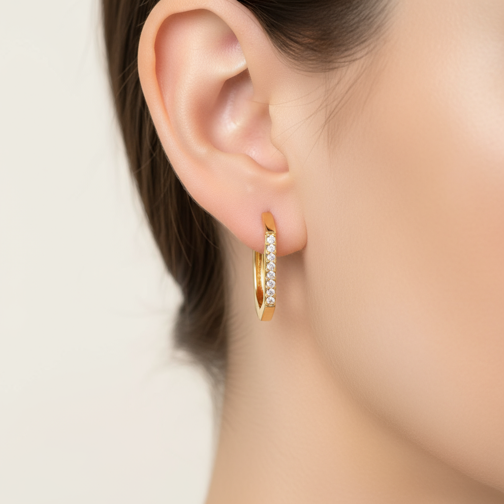 Single gold CZ hoop earring on model ear