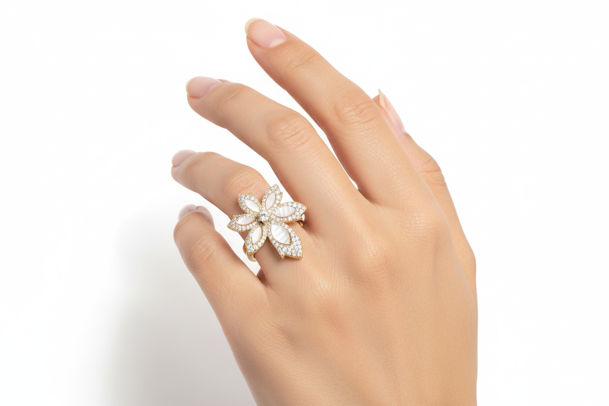 Small gold flower ring with mother of pearl on finger